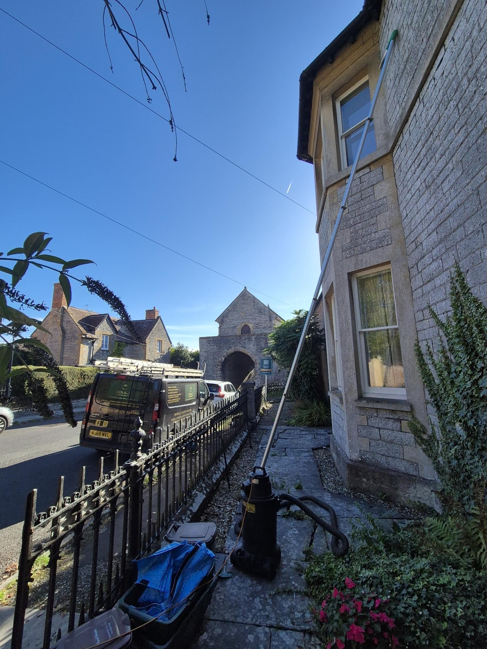 Gutter vacuum pole clearing the gutters of a stone house in Somerset