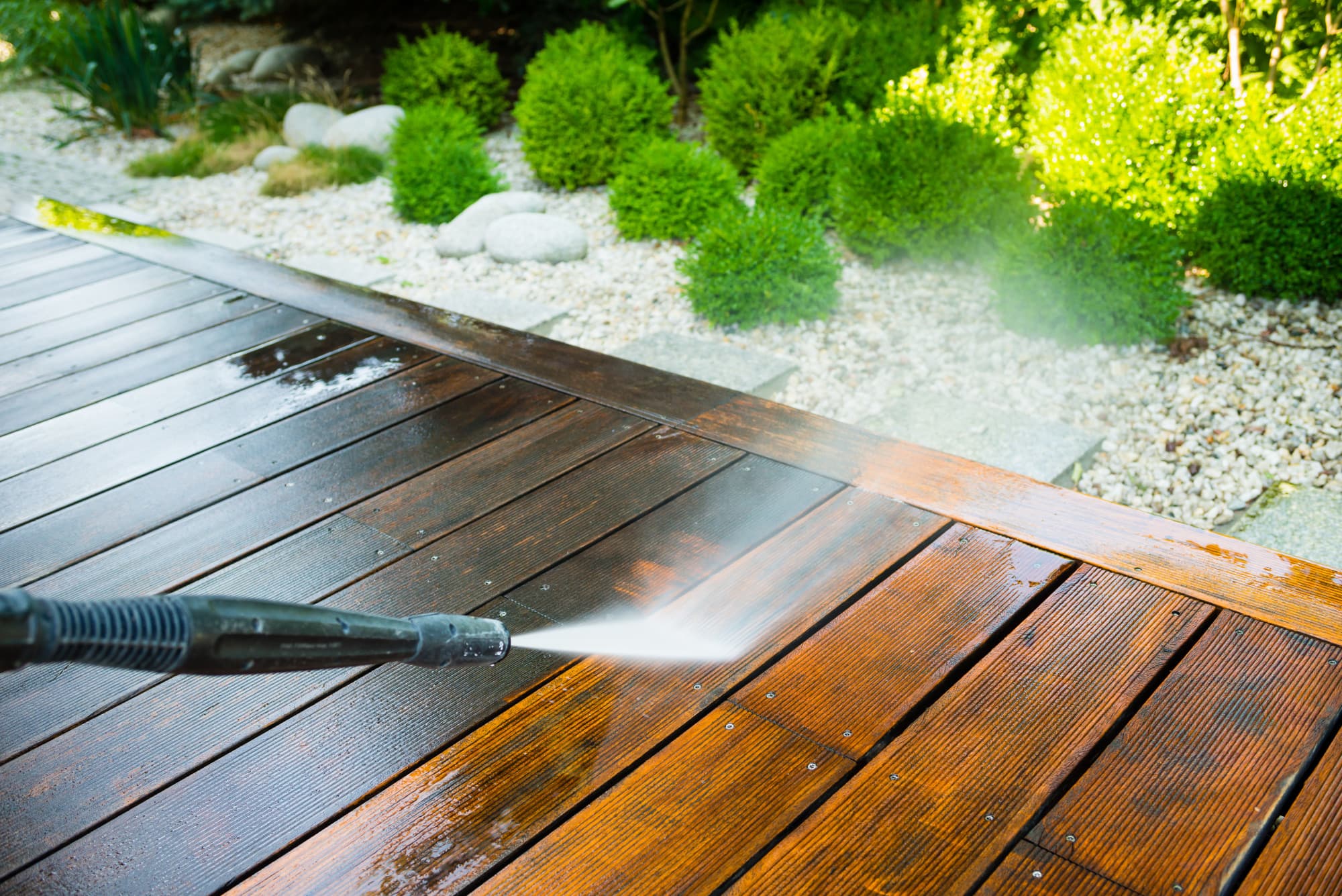 Wooden decking being pressure washed